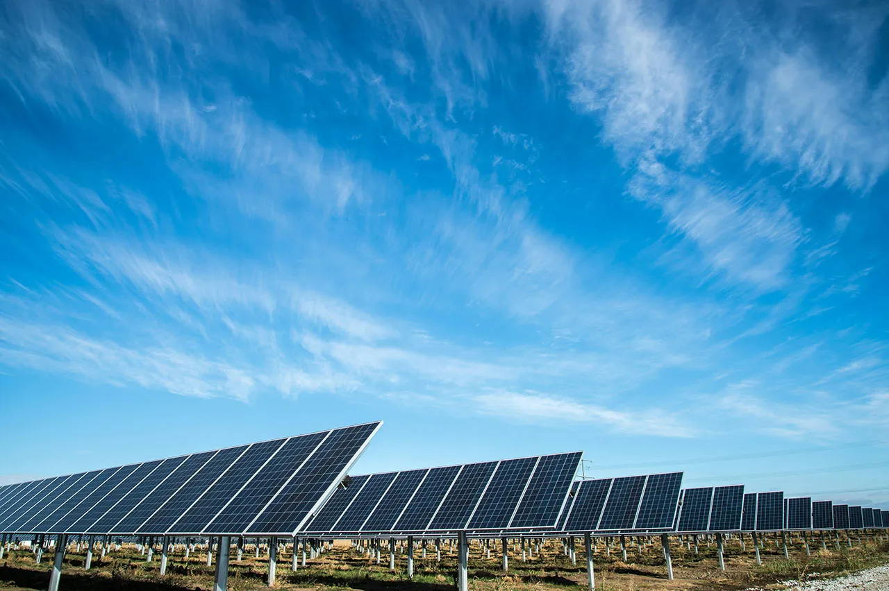 Utility-scale solar array under a blue sky
